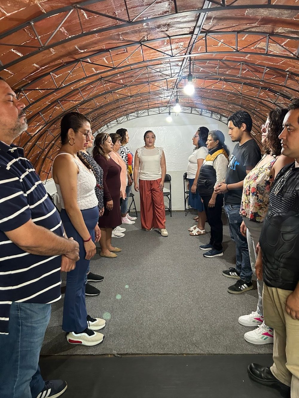 Participantes de pie, frente a frente, durante un Taller de Constelaciones Sistémicas de Alqhimia